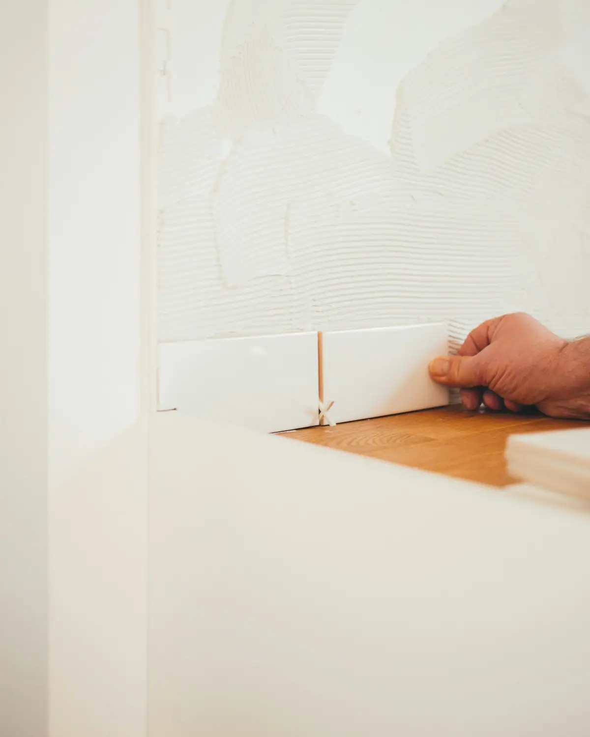 A tile setter's hands placing tile